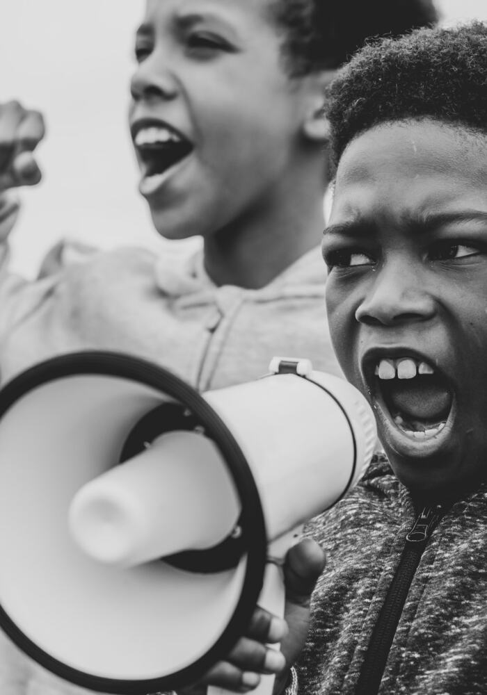 Young boy shouting on a megaphone in a protest